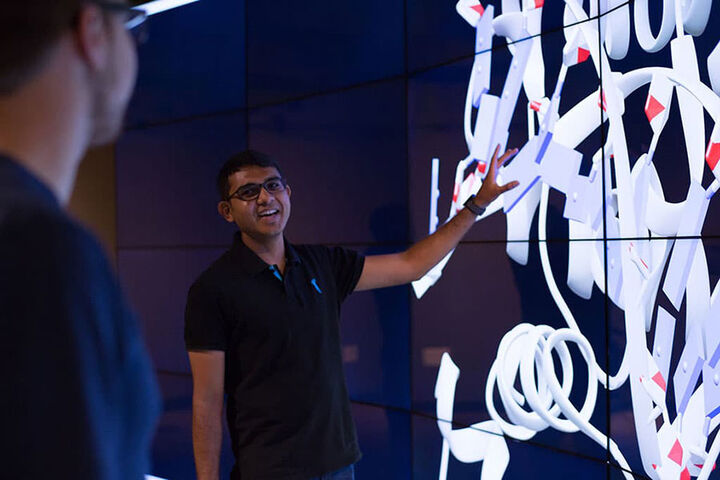 Informatics, Computing, and Engineering student stands in front of an IQ wall.
